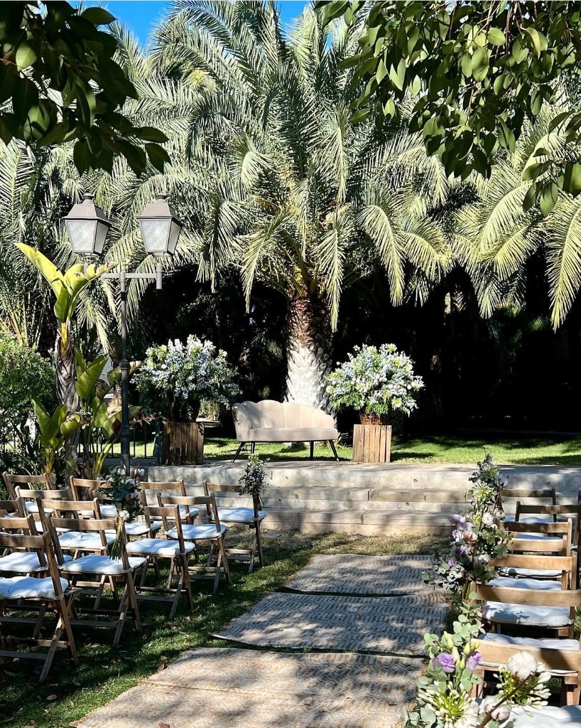 Espacio de ceremonia exterior rodeado de palmeras en Mas de Alzedo